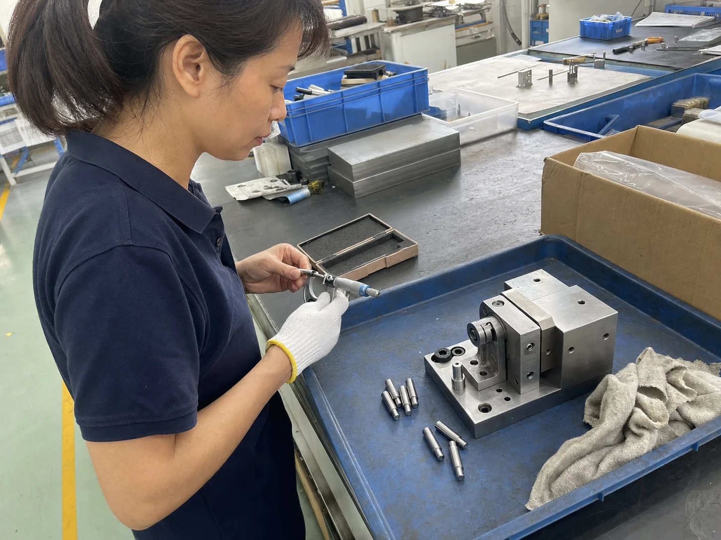 车间工艺技术员在试装台旁用千分尺复测SUS303定位销外径