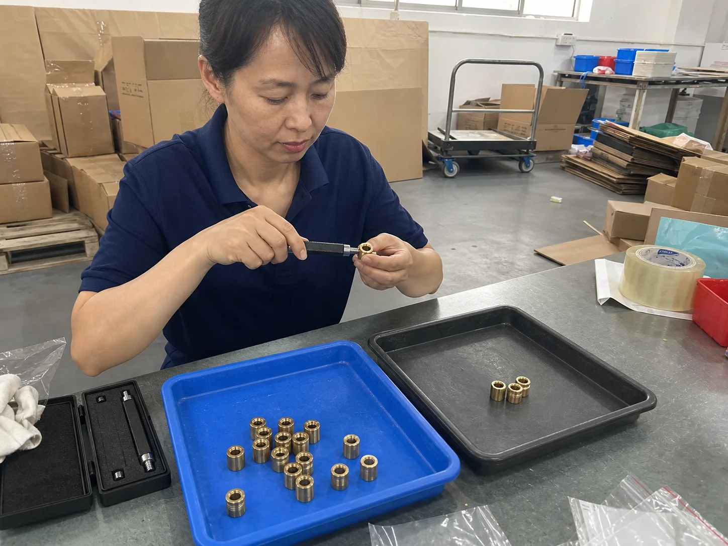 女性操作员在发货区用螺纹通止规复检H62黄铜螺纹套