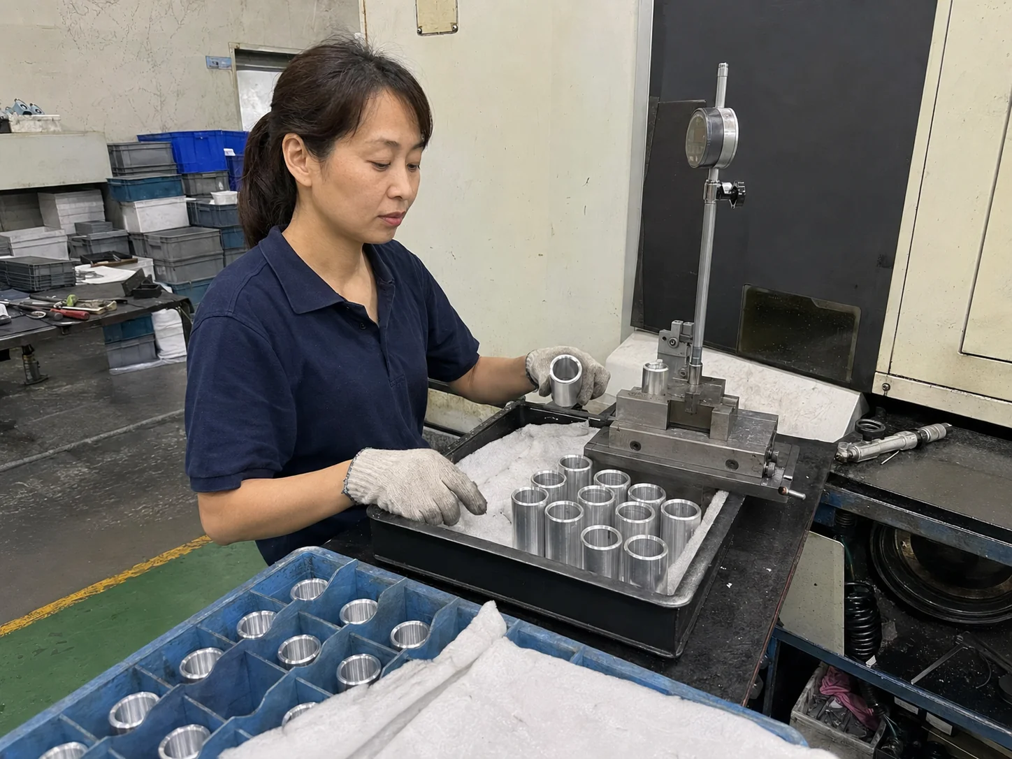 女性车间操作员在巡检台分开放置7075铝合金套筒并核对内孔量具